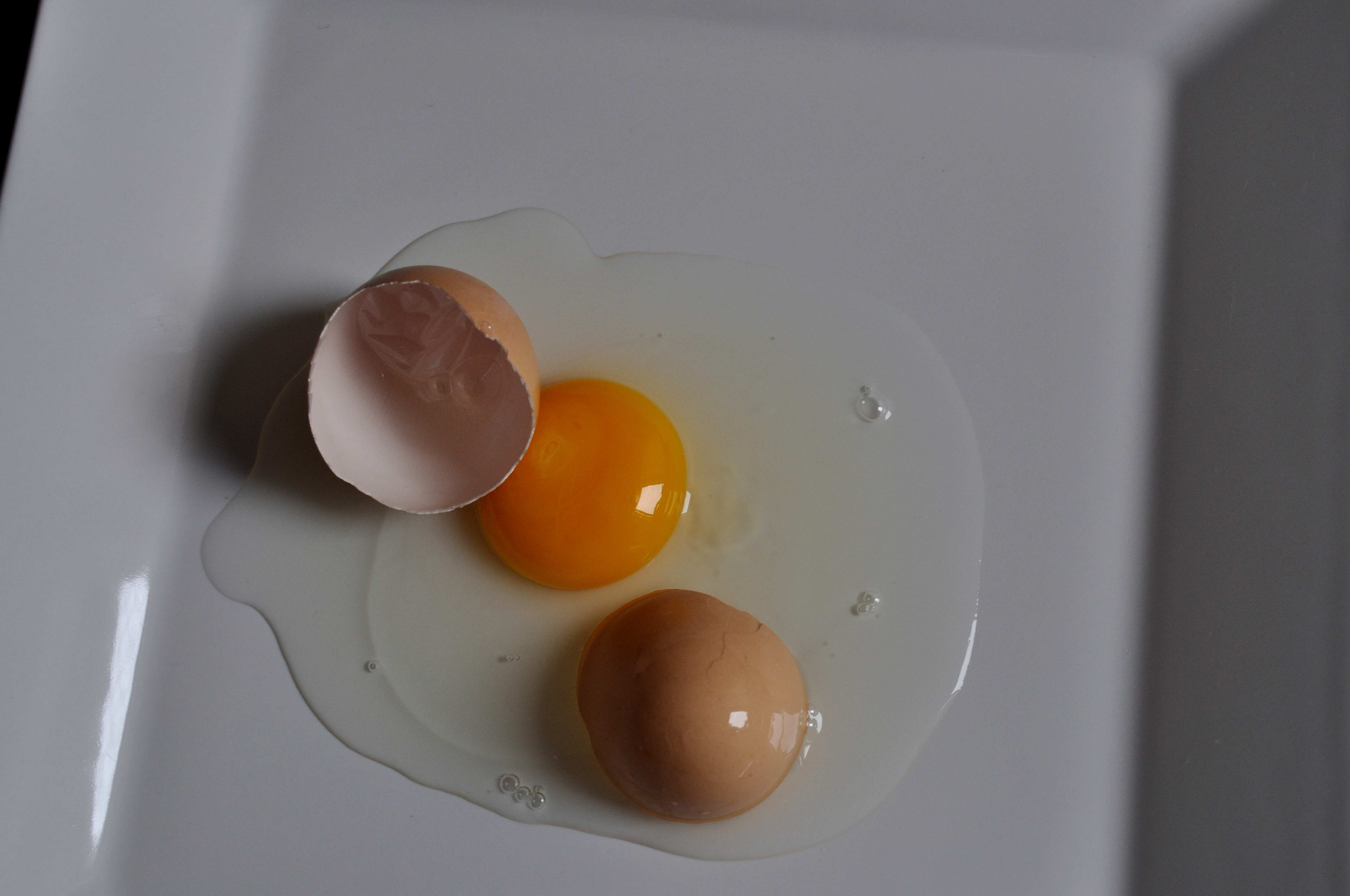Куриное яйцо без белка. Разбитое куриное яйцо. Желток яйца. Тёмный желток в курином яйце.