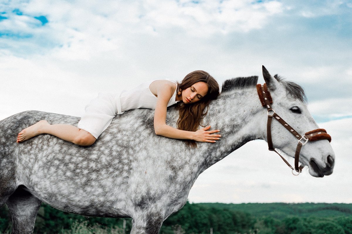 Девушка лежит на лошади